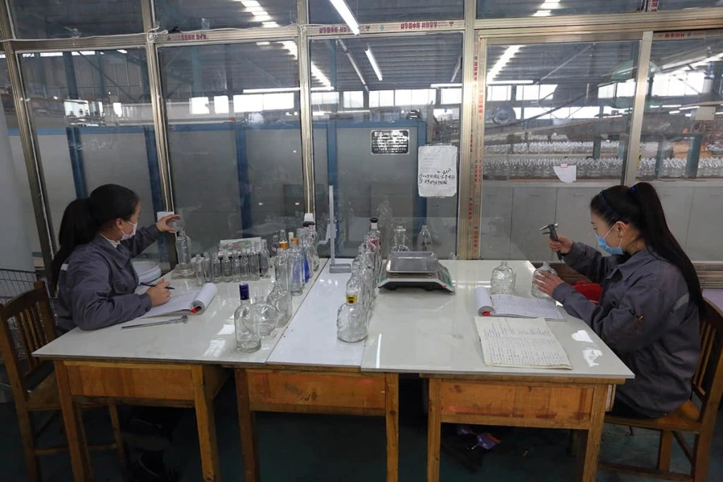 MAIDAO INDUSTRY laboratory team reviewing glass containers